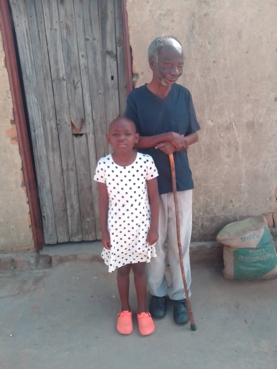 Melody standing with one of her grandparents